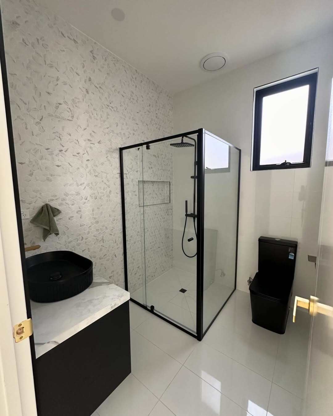 Modern bathroom with black fixtures and hexagon mosaic
